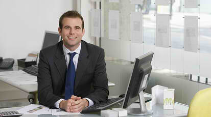 Smiling business man in front of a computer desk